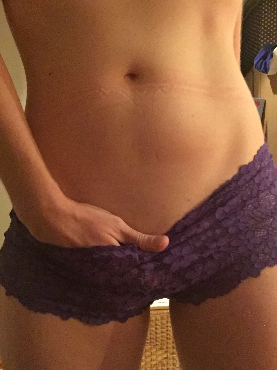 A colour photo of me wearing those purple lacy knickers with my right hand pushing inside the waistband